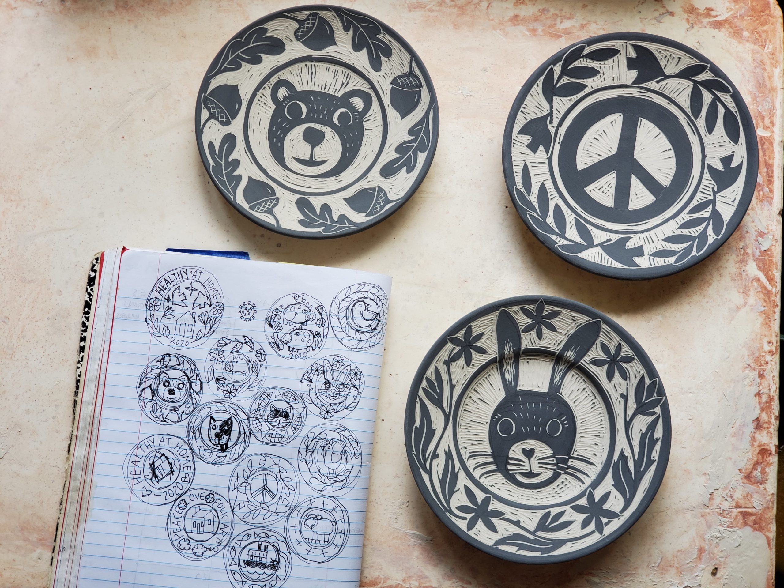 notebook with sketches and porcelain saucers with sgraffito designs