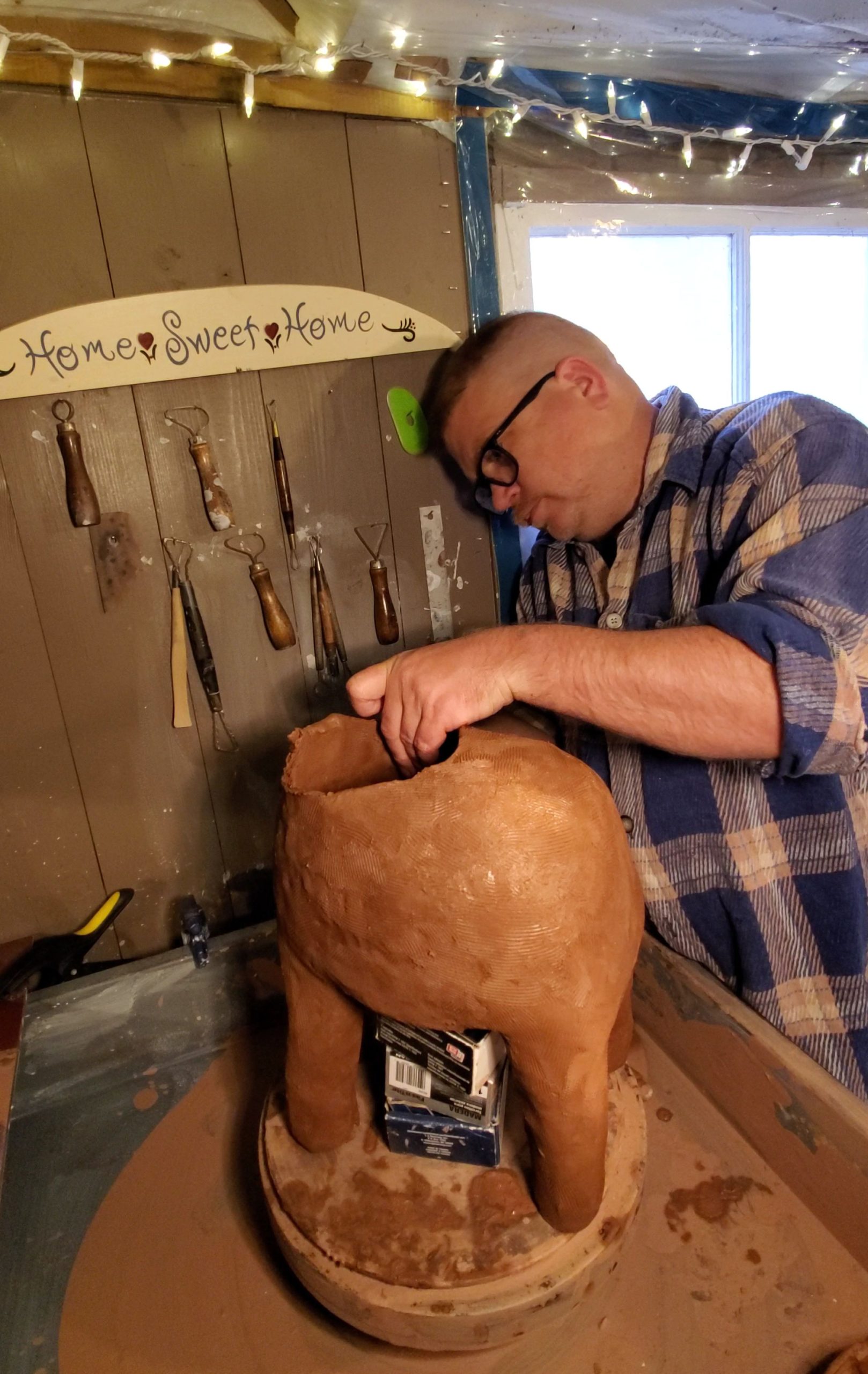 Artist Handbuilding clay bull sculpture