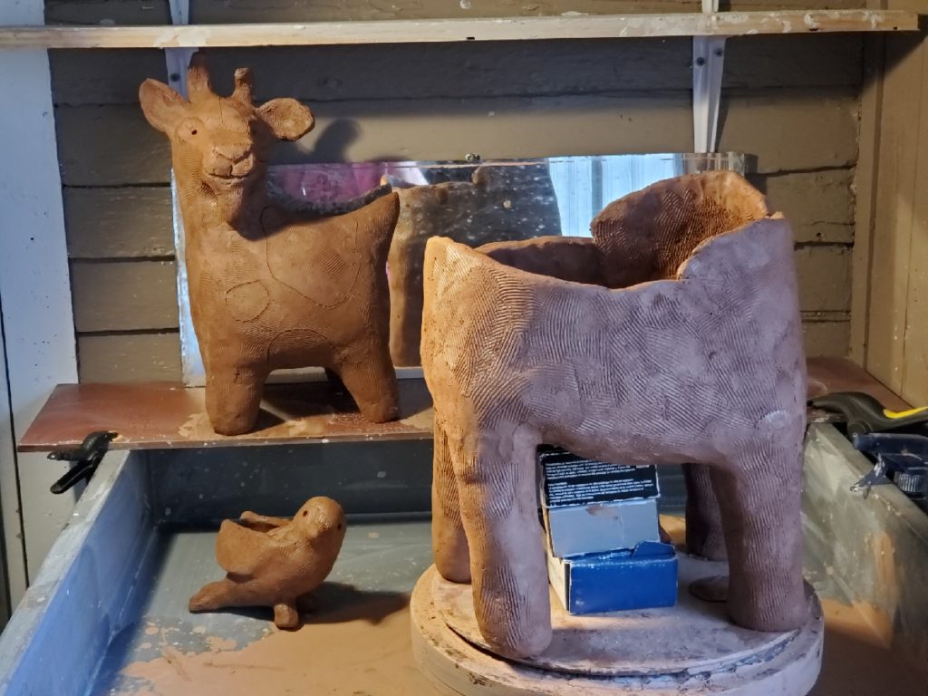 artist handbuilding clay animal