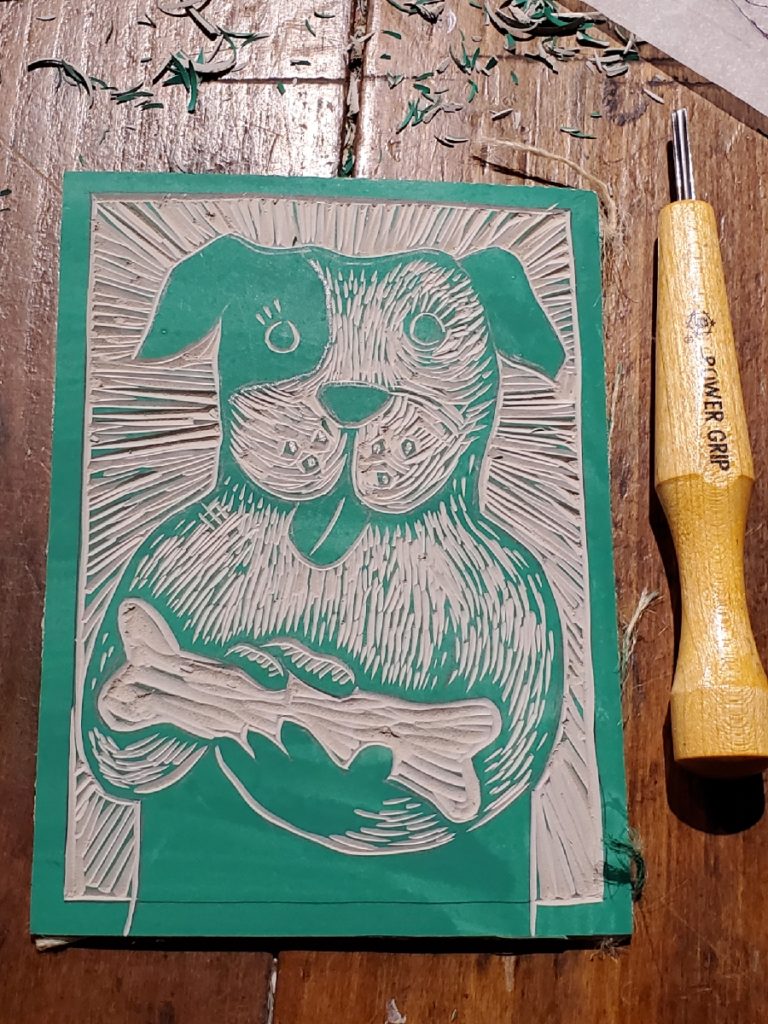 carved linocut of dog holding bone - ready to ink