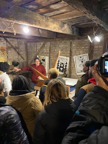 log cabin filled with students, doing a printmaking activity