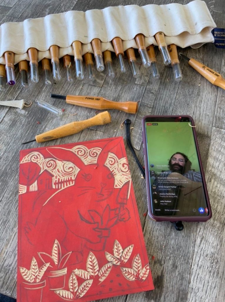 knives and a woodcut of a bunny rabbit in the garden. with a musican performing on a cell phone