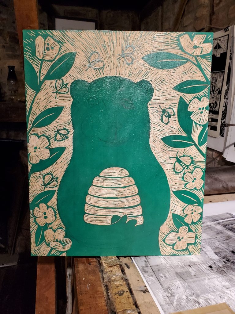 woodcut work in progress of a bear holding a beehive