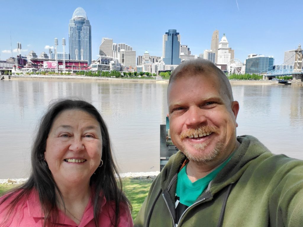 Ken Swinson and Connie Sanders standing in front of the ohio river with the cincinnati skyline in the background