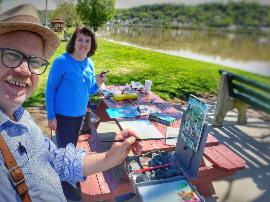 artists ken swinson and Kay schafer painting the view of maysville kentucky from the ohio river pairk in aberdeen ohio