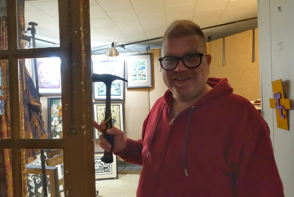 artist with hammer in studio