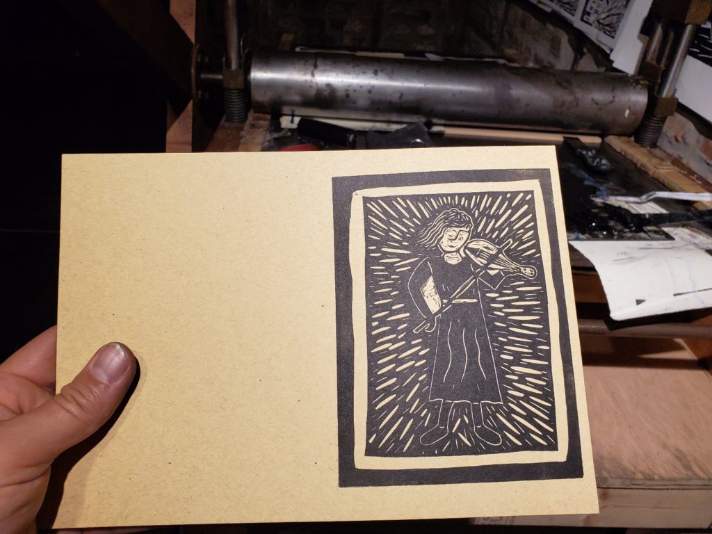 test proof of a linocut of lady playing violin by nick denham