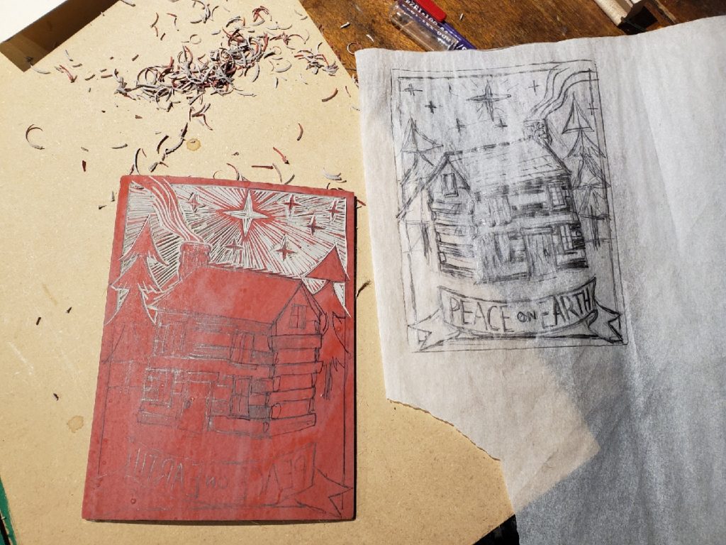 partially carved linocut and sketch of a cabin with star over it with text that says peace on earth