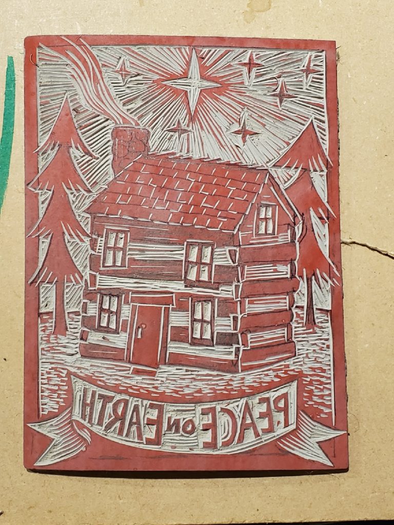 carved linocut of cabin with star - ready to be inked