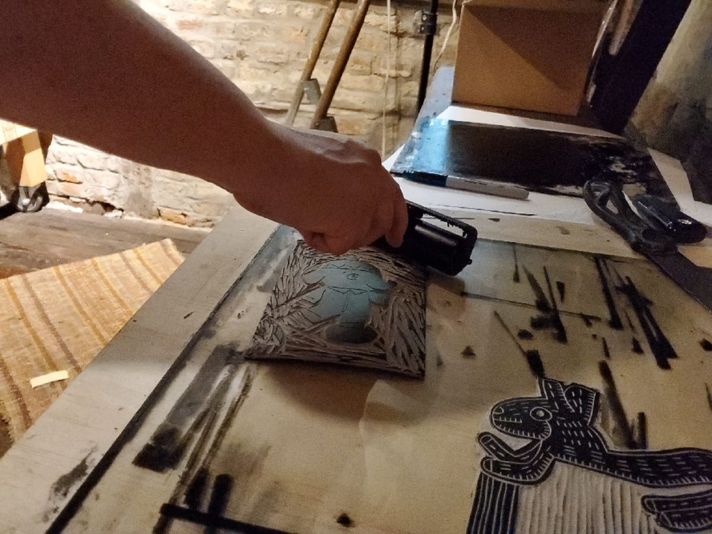 artist rachel bollman putting ink on a block print