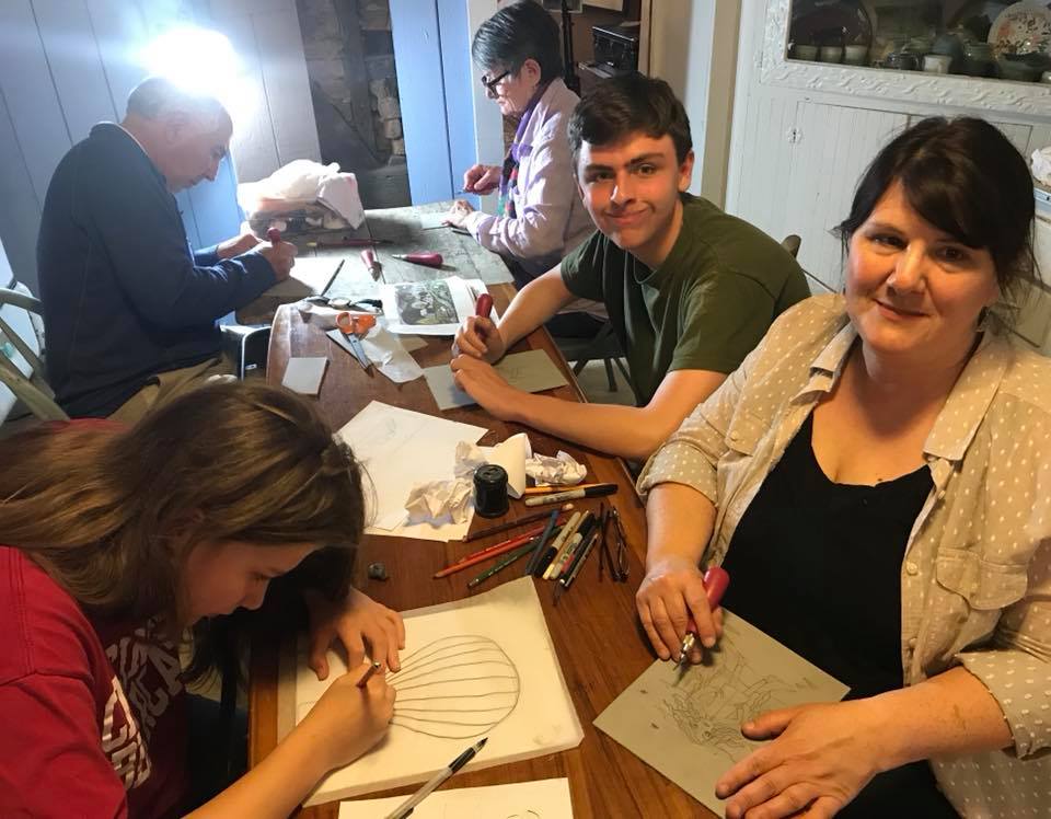 a family carving linocuts together