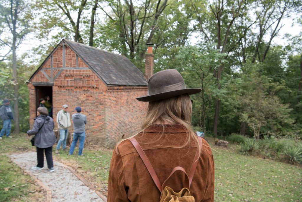 woman with hat walking to the Harlan Hubbard studio in ft thomas kentucky