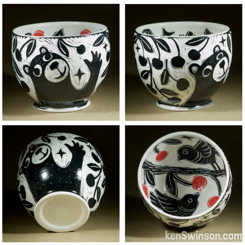 A wheel thrown porcelain bowl made by Kentucky artist, ken swinson-the bowl is decorated with black and white sgraffito design of bears picking cherries on the exterior. the interior has birds eating red cherries