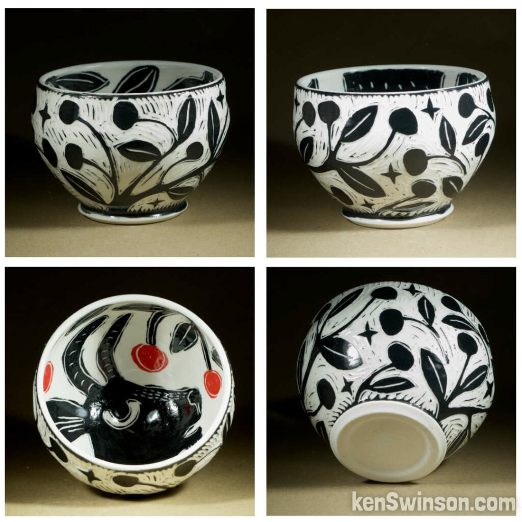 A wheel thrown porcelain bowl made by Kentucky artist, ken swinson-the bowl is decorated with black and white sgraffito design of cherries on the exterior. the interior has a goat eating cherries