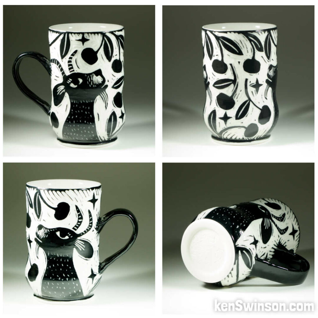 A wheel thrown porcelain cup with black and white sgraffito design of a goat eating cherries