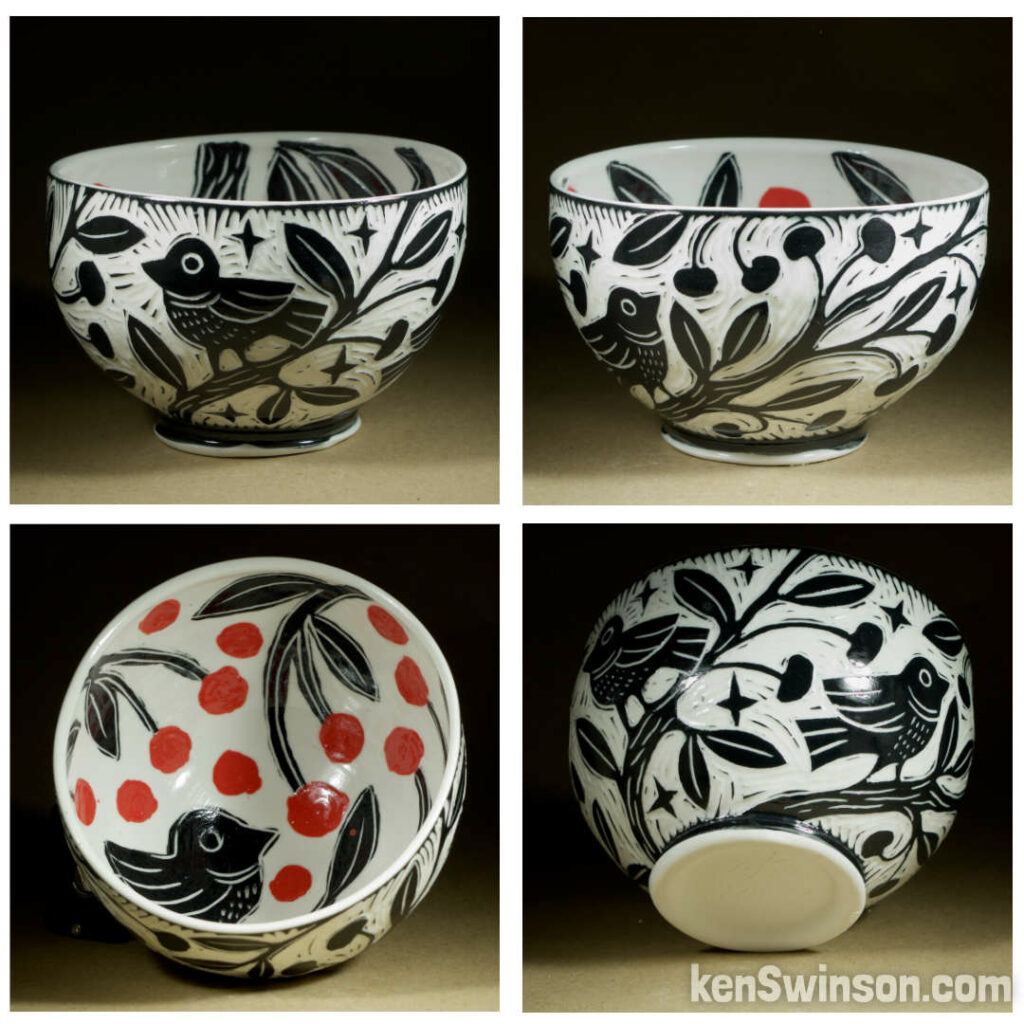 A wheel thrown porcelain bowl made by Kentucky artist, ken swinson-the bowl is decorated with black and white sgraffito design of birds on a cherry tree on the exterior. the interior has a bird eating red cherries