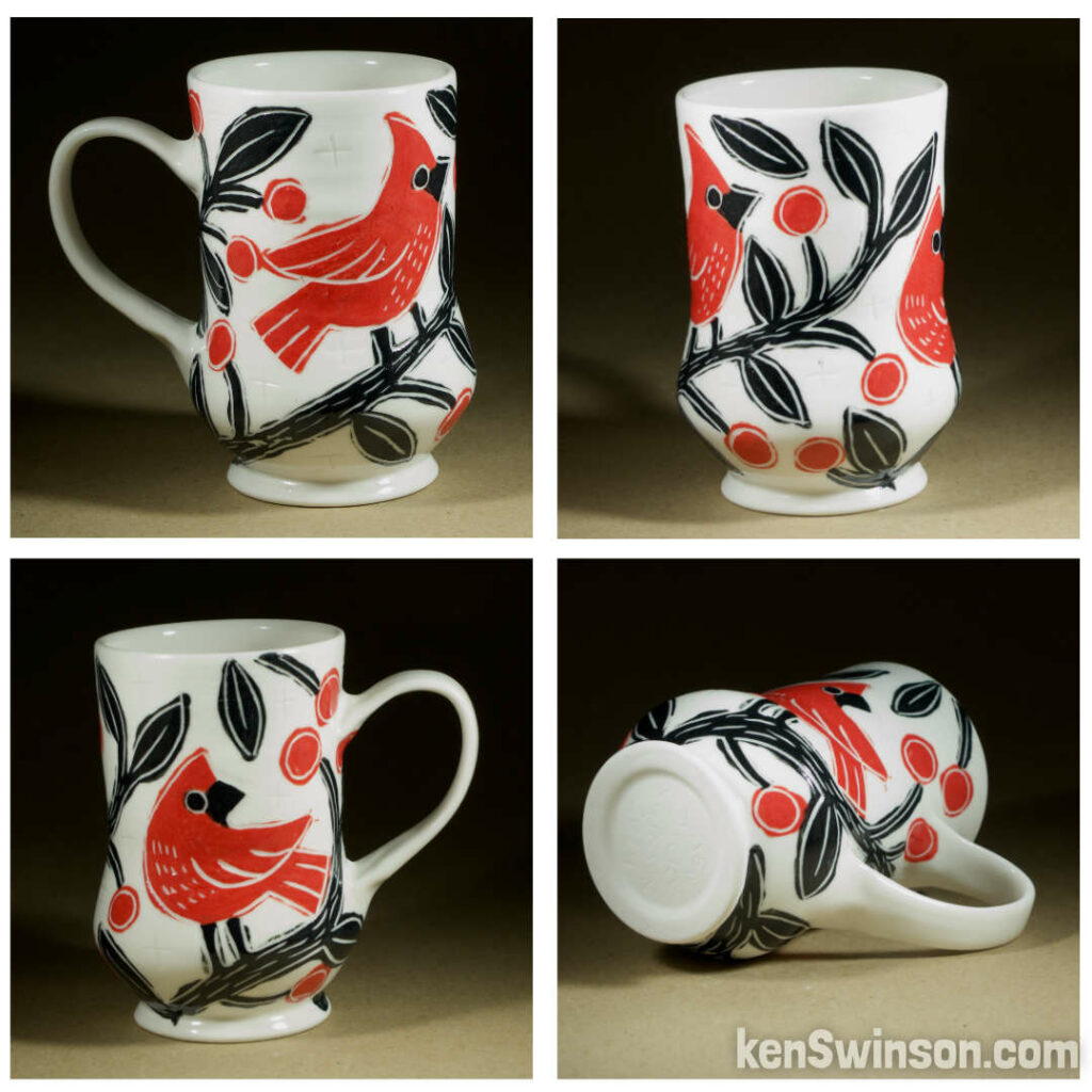 A wheel thrown porcelain cappuccino cup made by Kentucky artist, ken swinson-the bowl is decorated with black, white and red sgraffito design of cardinals in a cherry tree.