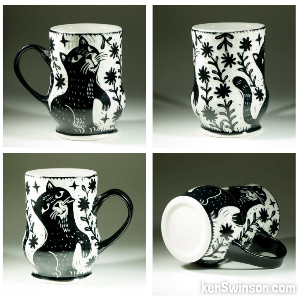 A wheel thrown porcelain cup with black and white sgraffito design of a cat surrounded by flowers