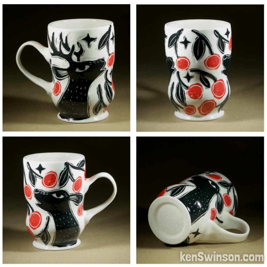 A wheel thrown porcelain cappuccino cup made by Kentucky artist, ken swinson-the bowl is decorated with black, white and red sgraffito design of deer eating cherries under a cherry tree.