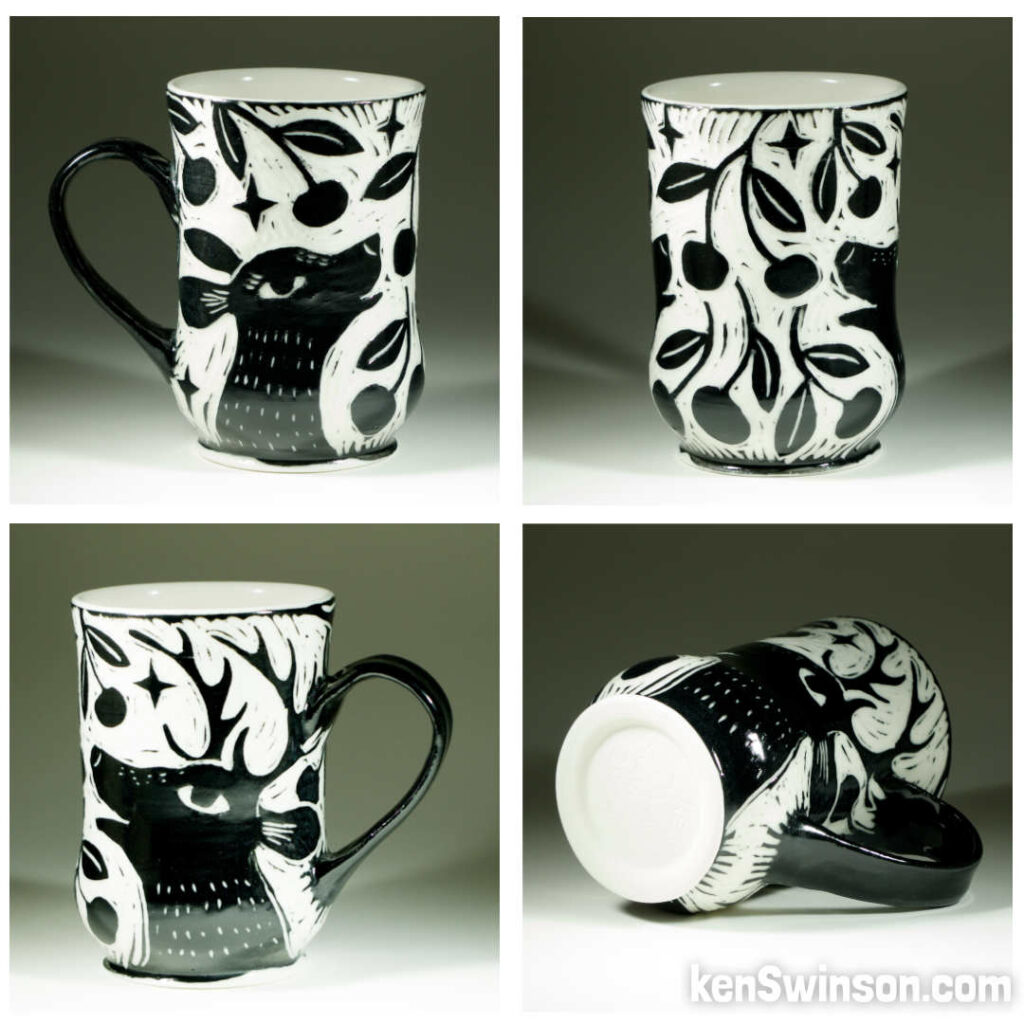 A wheel thrown porcelain cup with black and white sgraffito design of two deer eating cherries from a tree